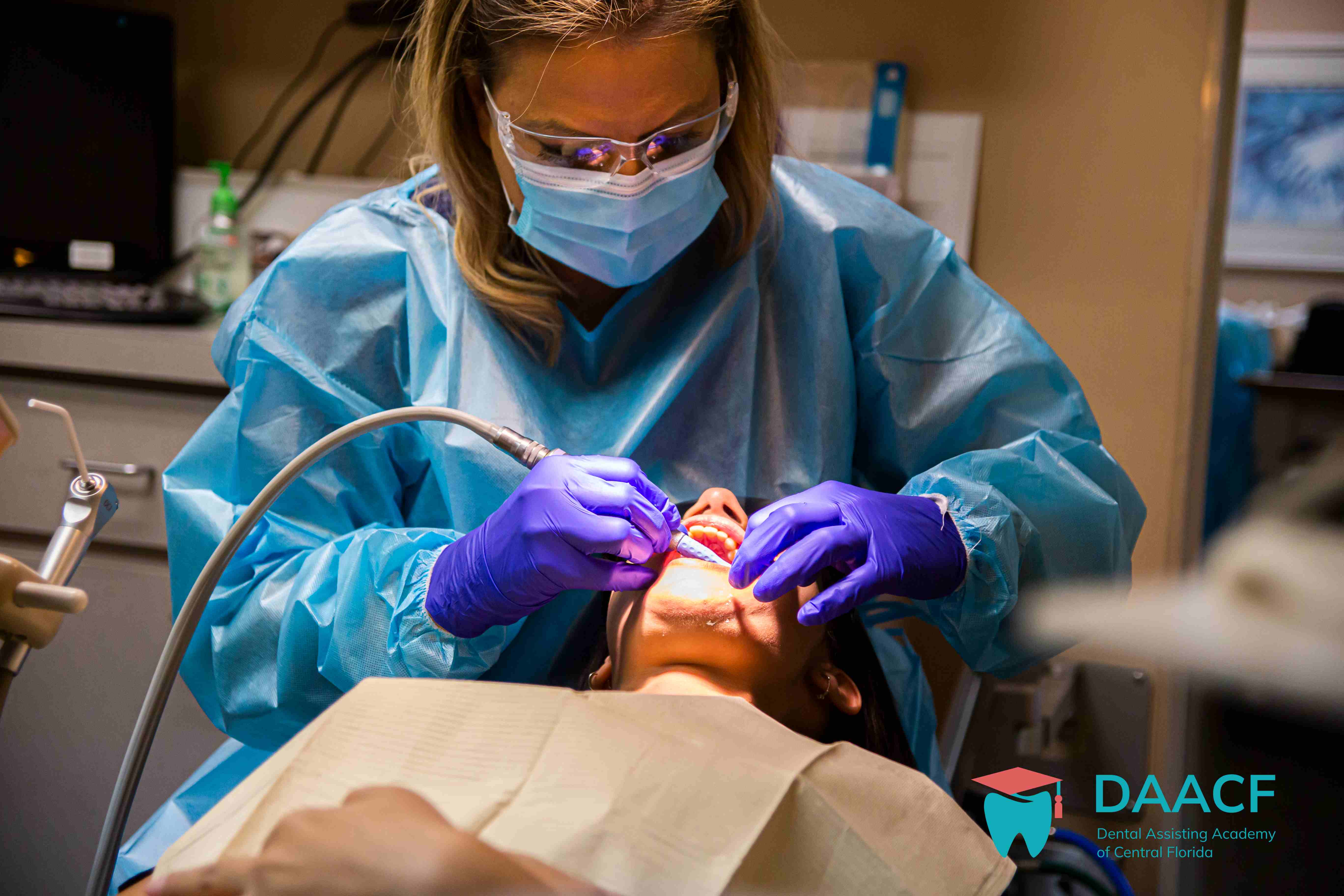 Professional dental assistant performing procedure with modern equipment at DAACF